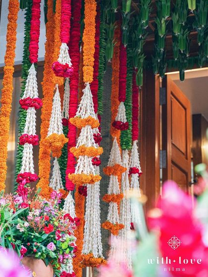 A vibrant floral curtain made of marigold and jasmine garlands for a Pellikuthuru ceremony. This traditional element adds a pop of color and fragrance to the home celebration.