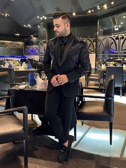 An elegant, full-length shot of the client in our striped sequin tuxedo, showcasing the complete, tailored look.