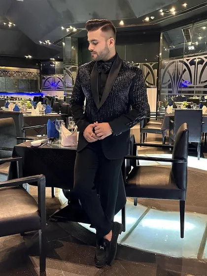 An elegant, full-length shot of the client in our striped sequin tuxedo, showcasing the complete, tailored look.