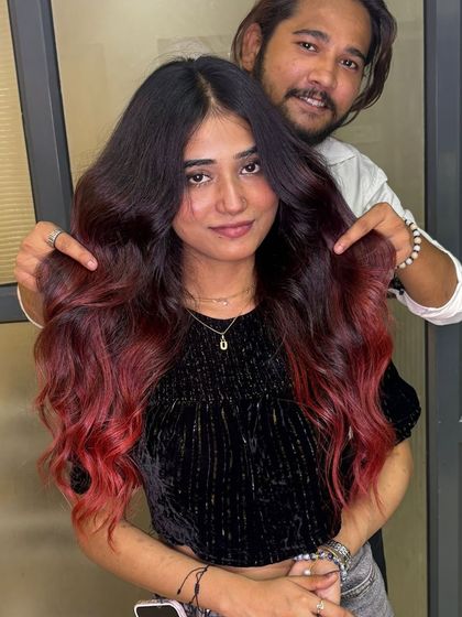 A happy client showing off her new plum red balayage. We love creating looks that make you feel confident and stylish.