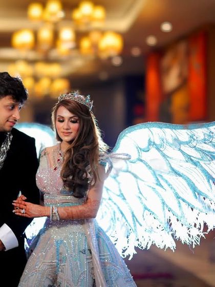 The couple together, with the bride's illuminated angel wings creating a magical glow. This is a perfect example of how we create one of a kind, fantasy like portraits.