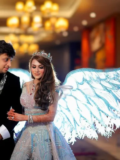 The couple together, with the bride's illuminated angel wings creating a magical glow. This is a perfect example of how we create one of a kind, fantasy like portraits.