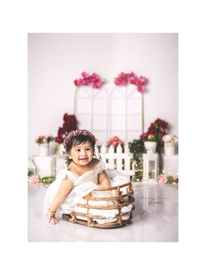 A beautiful sitter session in a garden of soft pinks and whites. Her happy smile and the lovely floral setting create a portrait that is both sweet and elegant.