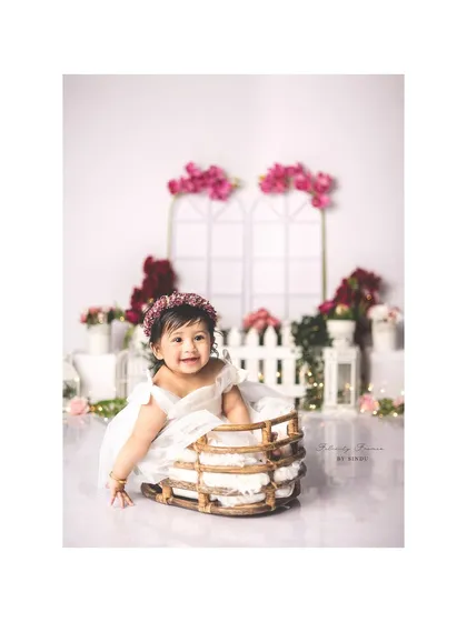 A beautiful sitter session in a garden of soft pinks and whites. Her happy smile and the lovely floral setting create a portrait that is both sweet and elegant.