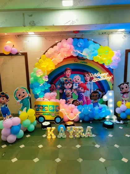 Another take on the popular Cocomelon theme, this time with a beautiful rainbow balloon arch over a custom backdrop. We also include a yellow school bus prop and light-up letters for the name.