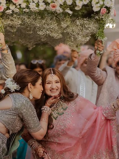 A sweet kiss from a sister or friend just before the bride goes on stage.