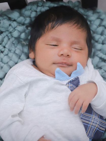 A close-up of a sleeping newborn in a tiny bed prop, looking absolutely peaceful. We focus on capturing their serene expressions.
