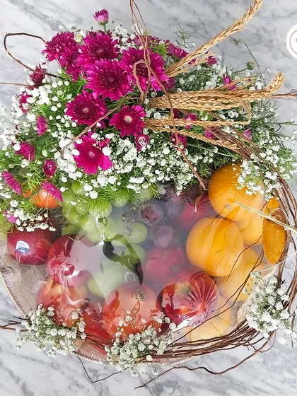 An overhead view of the fresh fruit hamper, showing the artful arrangement of fruits and flowers.