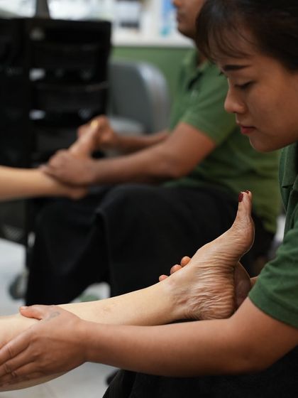 My therapist focuses on applying pressure to specific points on the foot during a reflexology-inspired massage. This technique helps release tension throughout the body.