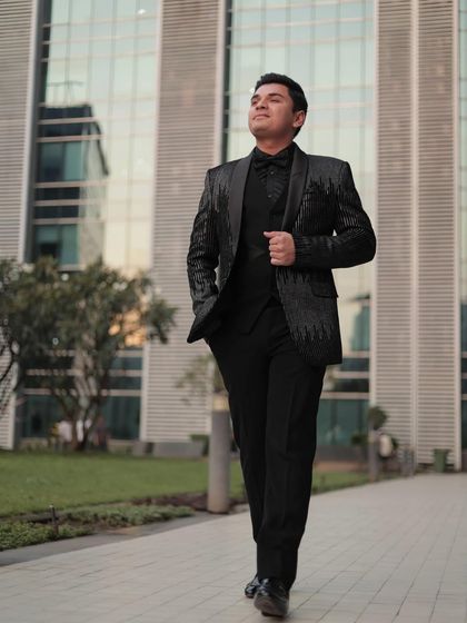Another shot of our client looking dapper in the sequin tuxedo. The modern architecture in the background complements the sleek, contemporary design of the suit.