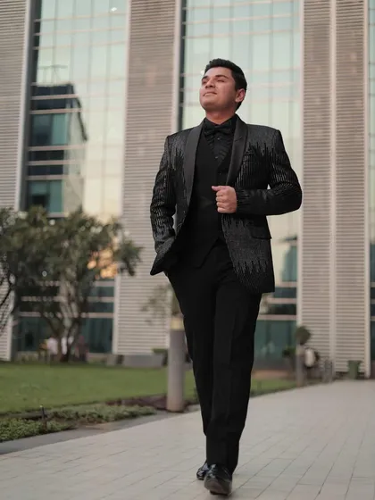 Another shot of our client looking dapper in the sequin tuxedo. The modern architecture in the background complements the sleek, contemporary design of the suit.