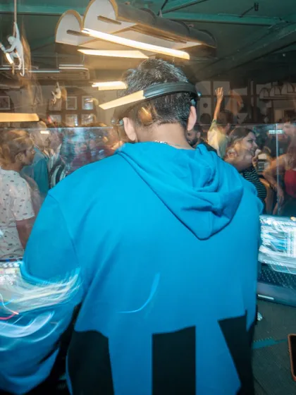 A creative long-exposure shot from behind the decks, capturing the movement and energy of the night.
