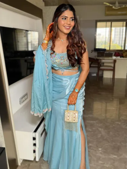 A full-length view of the client, ready for her event. The open hairstyle with soft curls balances the detailed embroidery of her modern lehenga.