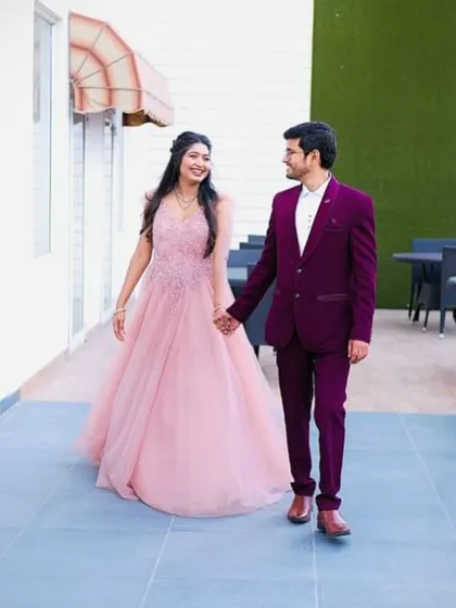 Modern elegance for a pre-wedding shoot or reception. This rich wine-colored tuxedo offers a contemporary twist on formal wear, perfectly complementing her beautiful pink gown. I help couples find looks that match their style and story.