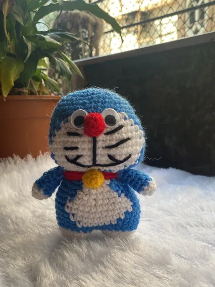 A finished Doraemon doll with playful googly eyes, ready to be shipped to his new home. Seeing a character come together stitch by stitch is the best part of my work.