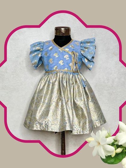 The Mogra blue dress is a perfect fusion piece. It combines a traditional brocade top with a modern metallic skirt, creating a comfortable and stylish frock.