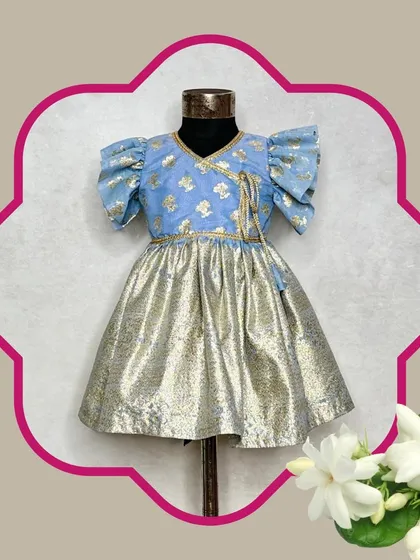The Mogra blue dress is a perfect fusion piece. It combines a traditional brocade top with a modern metallic skirt, creating a comfortable and stylish frock.
