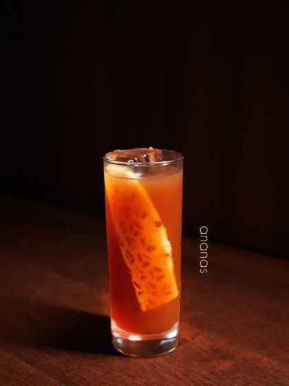 The Ananas cocktail showcases the rich, tropical flavor of pineapple. We build this drink around the fruit's natural sweetness and tang, served with a large slice of pineapple as a garnish to enhance its bold character.