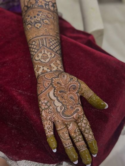 A single hand adorned with a beautiful paisley and floral design, showing the rich color of the henna.