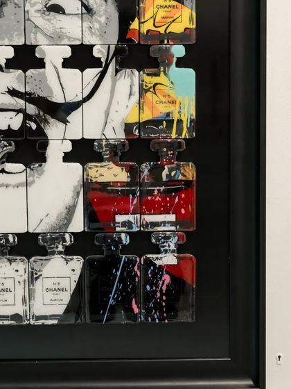 A close-up showing the right side of the "Dali In A Bottle" piece, with its mix of graphic art and brand logos.