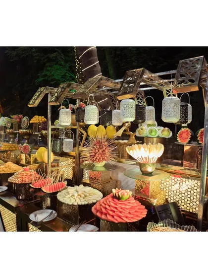A close-up of the fruit station, showcasing intricately carved watermelons and a wide variety of fresh, colorful fruits.