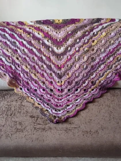 The Virus Shawl spread across a sofa, showing its generous size.