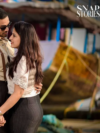 A close-up, intimate shot of a couple at a fishing dock, with the rustic boats in the background adding unique character to their pre-wedding photos.