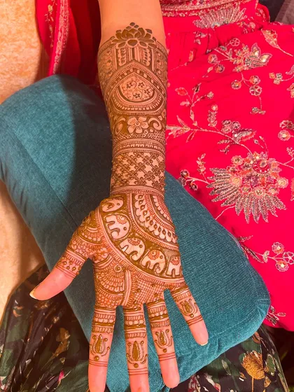 This bridal design features beautiful elephant motifs and intricate patterns, extending up the arm for a classic and elegant look.