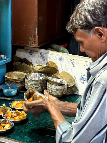 A local vendor expertly prepares a plate of chaat. On our food walks, we introduce you to the artisans who have been perfecting these recipes for generations, giving you a true taste of tradition.