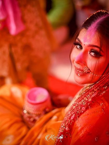 A candid, over-the-shoulder shot of a bride during a ceremony, looking up with a smile.
