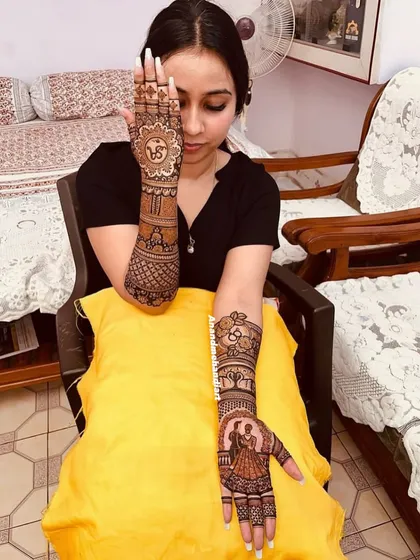 A client posing with her custom bridal mehndi.