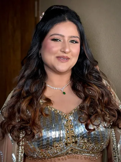 A happy and confident bride, ready for her Sangeet night. The makeup enhances her glow and looks beautiful with her diamond necklace.