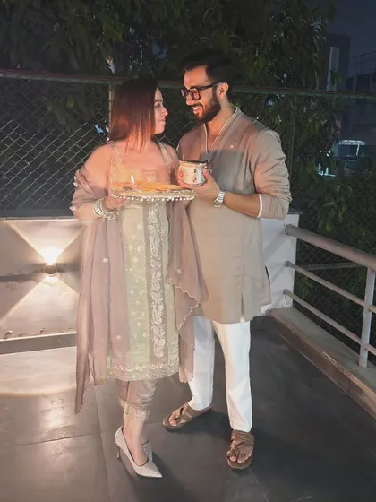 Celebrating their bond under the evening lights. This shot, with the couple holding a decorative thali, brings a festive and traditional feel to their outdoor pre-wedding photoshoot.