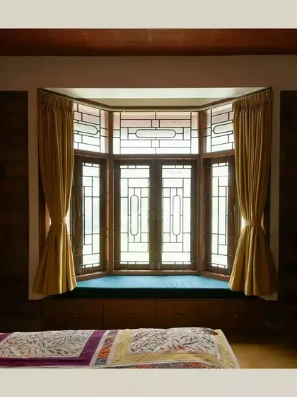 A cozy bay window seat provides a perfect nook for reading or enjoying the view, flooding the bedroom with natural light while adding architectural character.