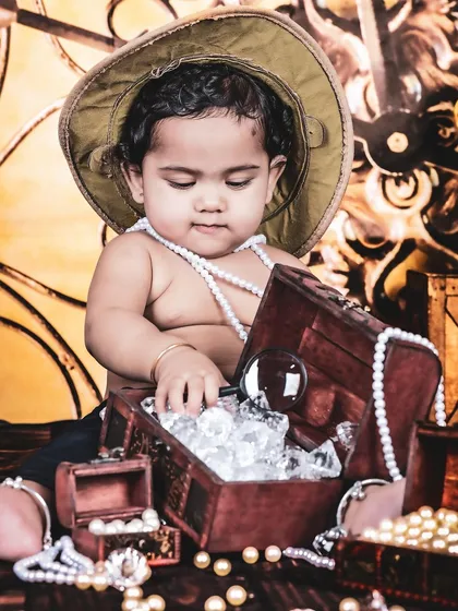 A young explorer on a treasure hunt, discovering a chest full of jewels. The map background and props create a sense of adventure.