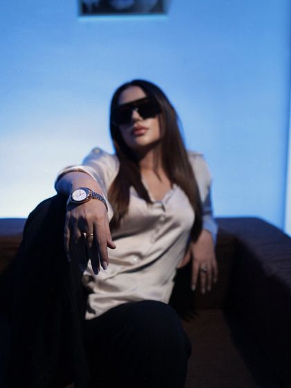 A powerful, boss-lady pose in sunglasses, a silk shirt, and a statement watch.