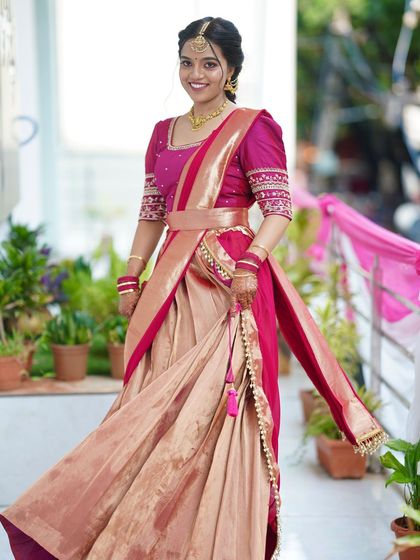 A full-length shot of a bride in a beautiful half-saree. The makeup is kept fresh and minimal to let the unique outfit shine.