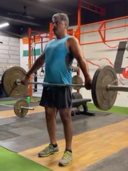 A lifter at the start of a snatch pull from the hang. This position emphasizes the role of the upper back and arms in keeping the bar close to the body.