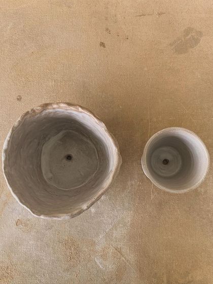 A pair of pots that didn't turn out as planned, but are beautiful in their own right. The larger one has a wonderfully organic, irregular rim.