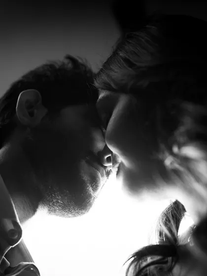 A moment just before a kiss, captured with beautiful backlighting. This black and white silhouette is intimate and full of anticipation.