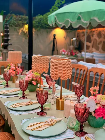 The warm glow from the wicker table lamps creates a cozy and inviting atmosphere for guests to dine and celebrate.