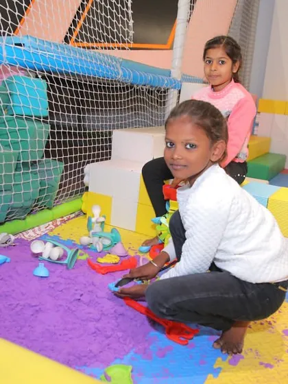 Children enjoying the kinetic sand pit during a special community event at Funville.