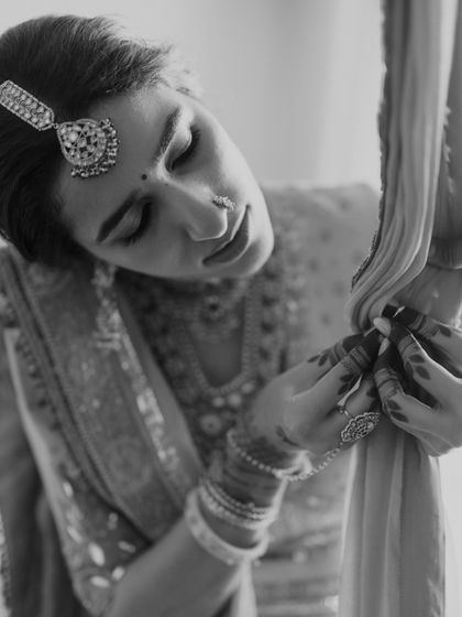 A close-up of the bride adjusting her dupatta, a quiet moment of preparation.