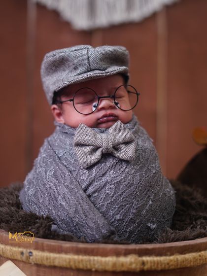 A little gentleman in the making. This vintage theme with a newsboy cap, tiny glasses, and a bow tie is so charming. The rustic wooden bucket completes the look.