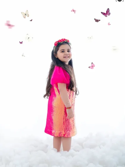 In a world of white whispers and butterfly wings, she blooms in pink magic. A dreamy, ethereal portrait.