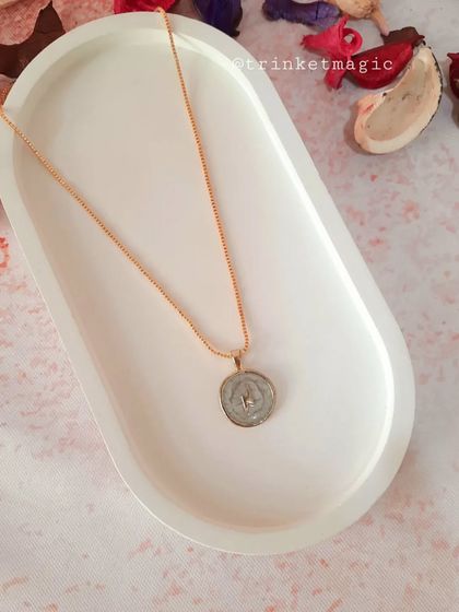 This celestial necklace features a star inside a white enamel pendant, perfect for those who love starry, cosmic-inspired jewelry.