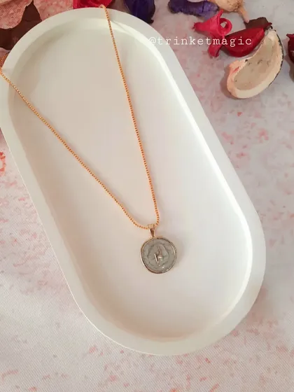 This celestial necklace features a star inside a white enamel pendant, perfect for those who love starry, cosmic-inspired jewelry.