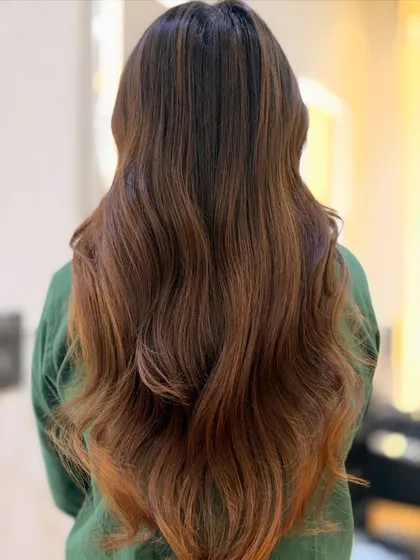 The back view of this gorgeous cinnamon brown hair, styled with soft, flowing waves. This look is all about healthy, glossy hair that moves beautifully.