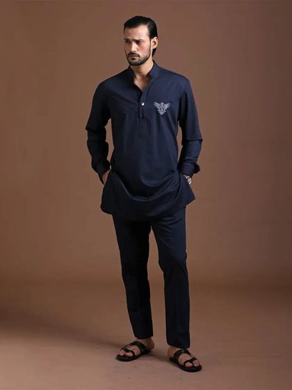 A modern, dark navy pathani-style kurta set. The subtle embroidery on the chest adds a touch of distinction to this sharp, contemporary ethnic look.
