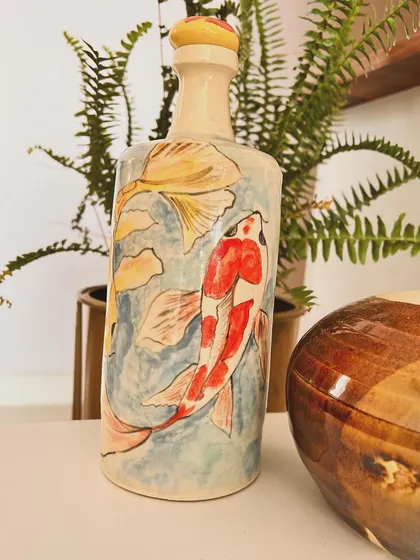 I really enjoyed painting these graceful koi fish onto a bottle vase. Using soft watercolors on the ceramic surface brings the design to life. This hand-painted vase is a unique piece of home decor that adds a touch of tranquility to any space.